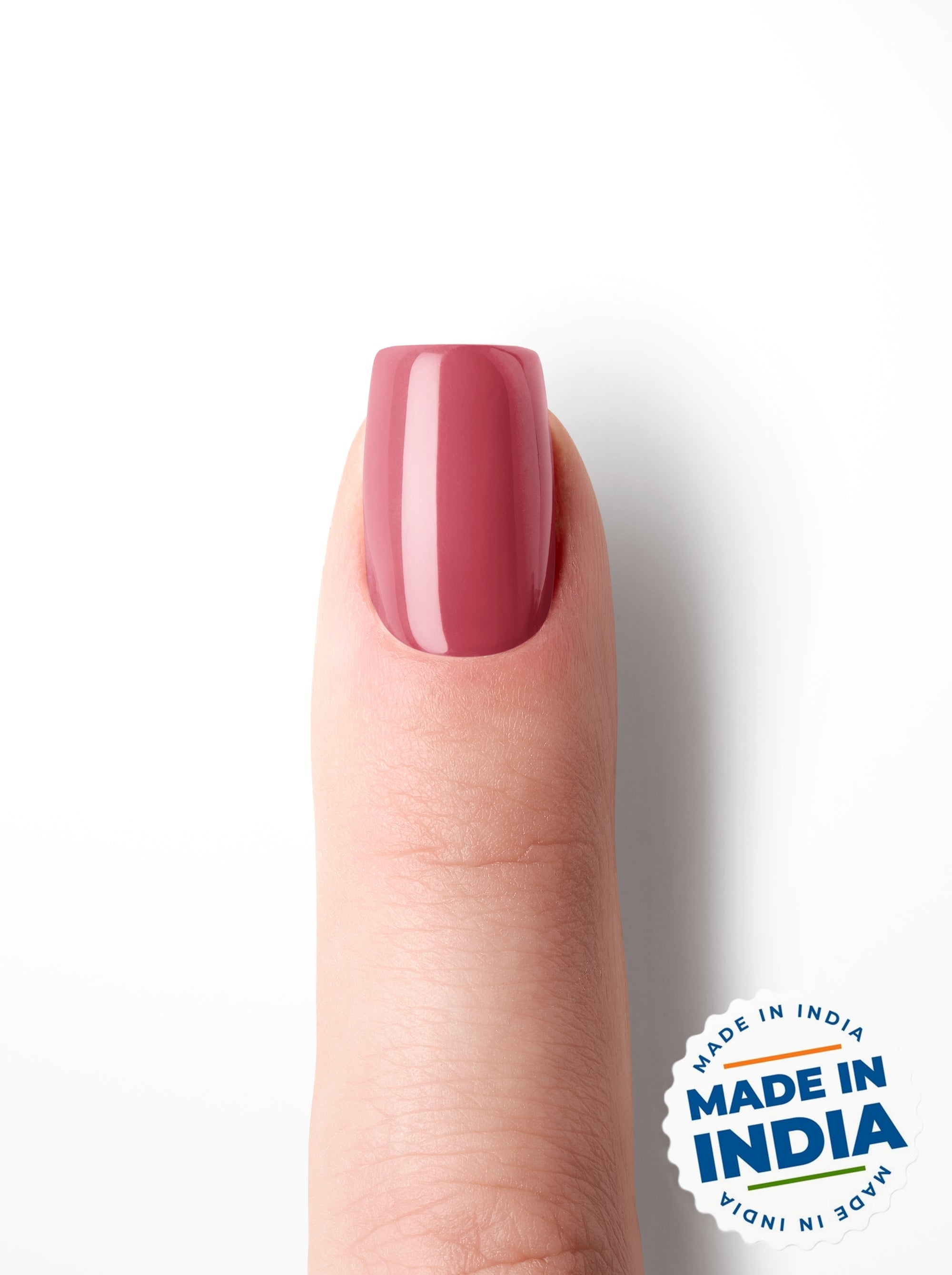 Finger with pink nail polish on a white background with 'Made in India' label