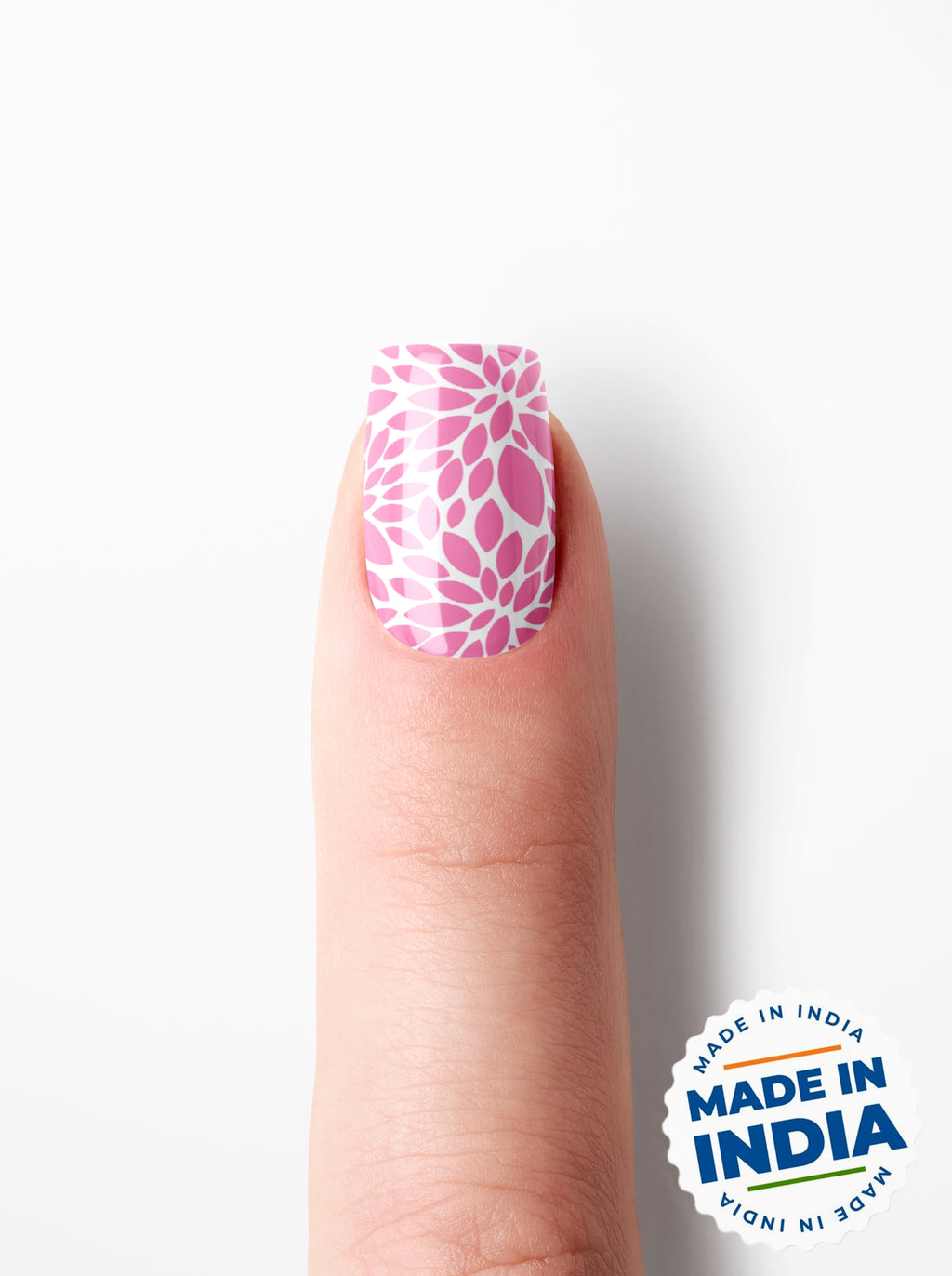 Finger with pink floral nail design on a white background with 'Made in India' badge.