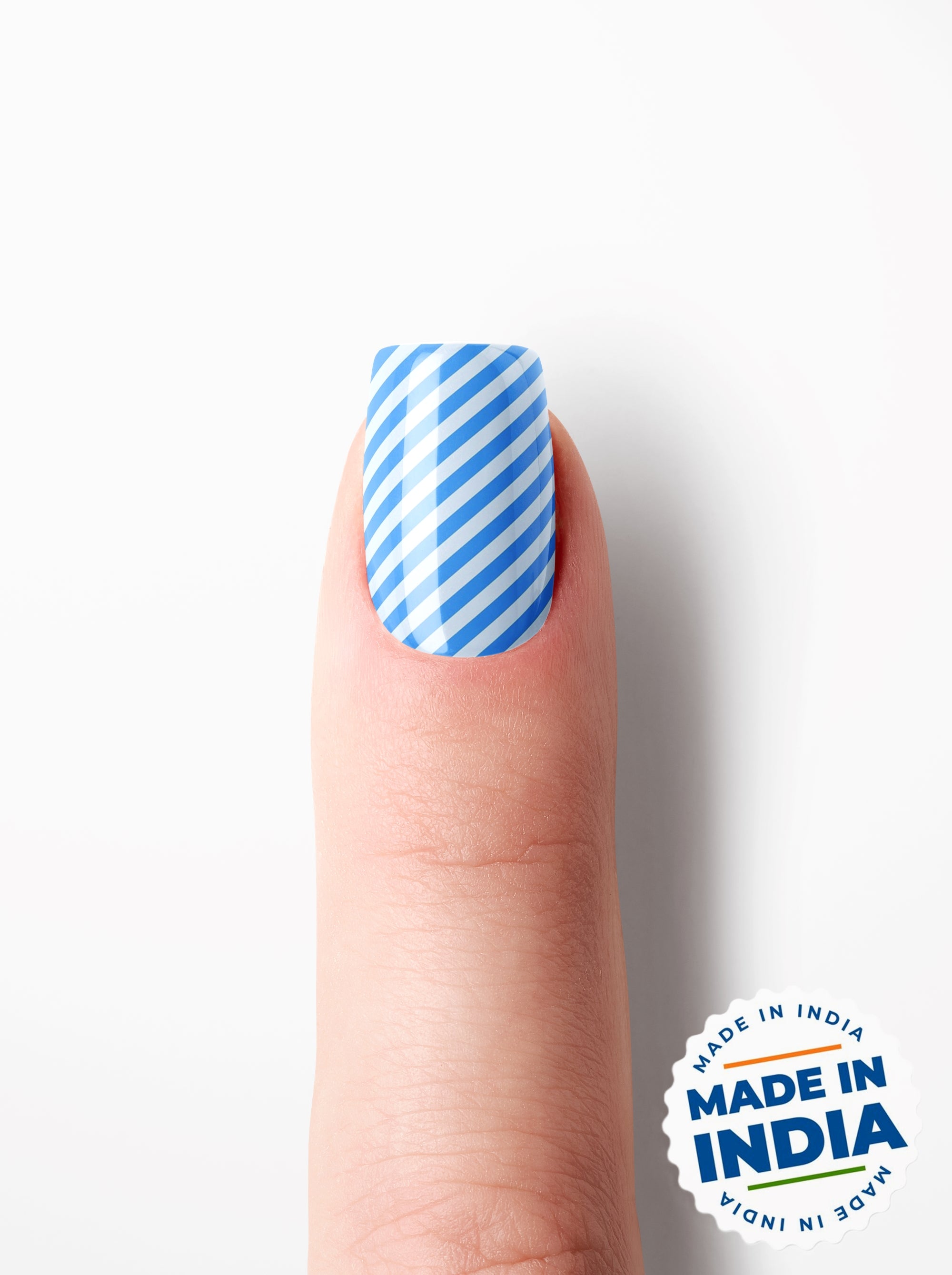 Nail polish with blue and white striped design on a finger, 'Made in India' label in the corner.